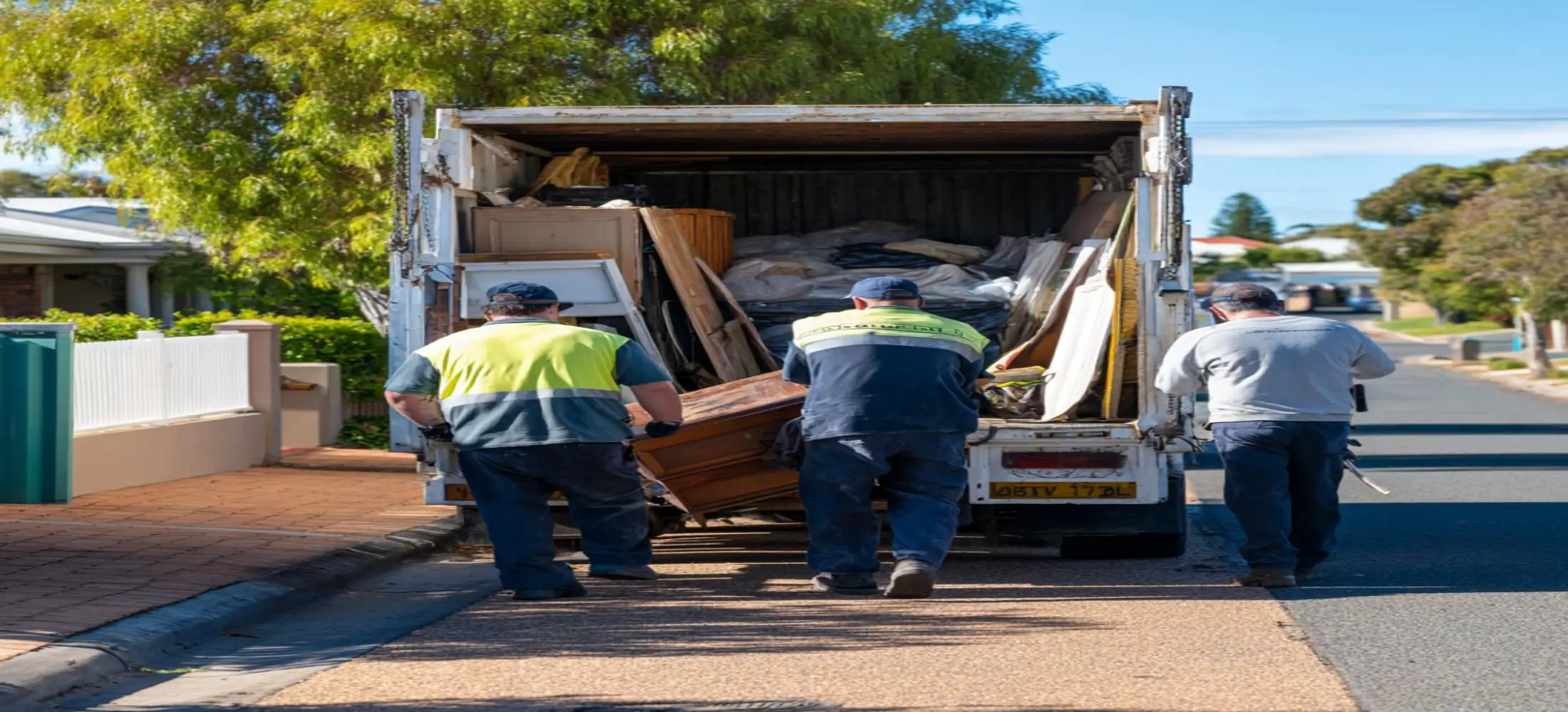 Rubbish removal team loading household waste and unwanted furniture outside a Bunbury property during a rubbish removal Bunbury service